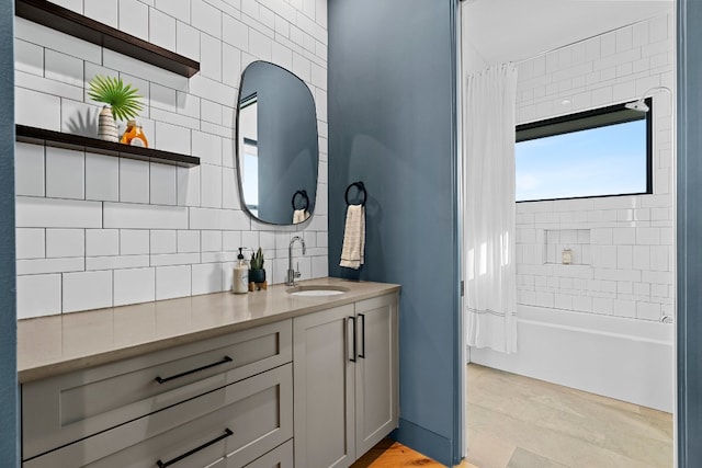 bathroom with tile walls, shower / bath combination with curtain, vanity, and backsplash