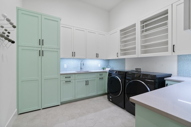 washroom featuring cabinets, sink, separate washer and dryer, and light tile floors