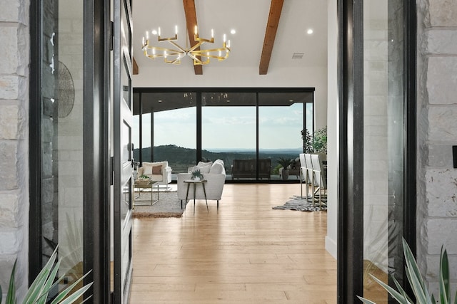 interior space featuring beamed ceiling, hardwood / wood-style floors, and an inviting chandelier