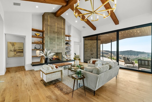 living room featuring a mountain view, a fireplace, high vaulted ceiling, light wood-type flooring, and beam ceiling