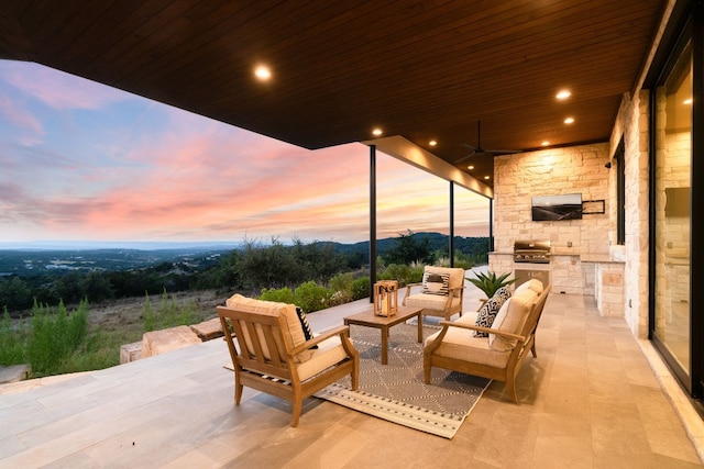 patio terrace at dusk with ceiling fan, a grill, and outdoor lounge area