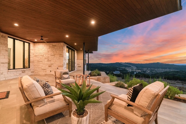 patio terrace at dusk with outdoor lounge area and a mountain view