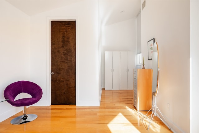 hallway featuring hardwood / wood-style flooring and vaulted ceiling