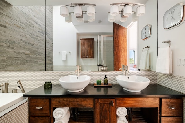 bathroom with vanity, walk in shower, and tasteful backsplash