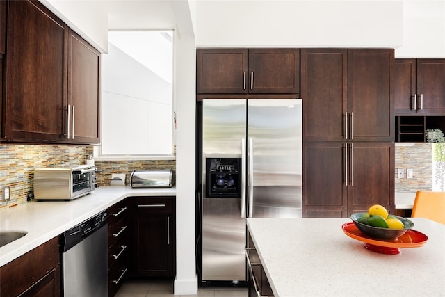 kitchen featuring decorative backsplash, dark brown cabinets, and stainless steel appliances