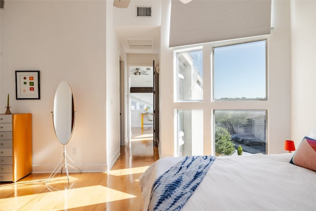 bedroom with a high ceiling and light hardwood / wood-style flooring