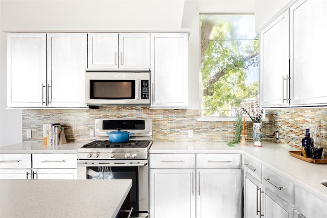 kitchen with backsplash, white cabinetry, and appliances with stainless steel finishes