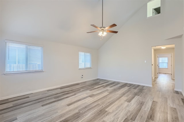 spare room featuring high vaulted ceiling, light hardwood / wood-style floors, and ceiling fan