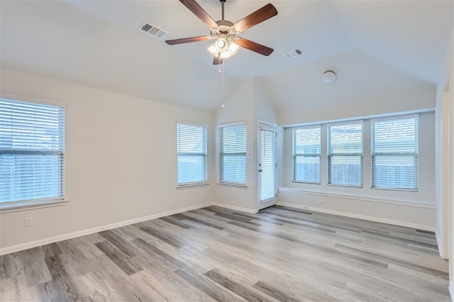 spare room with high vaulted ceiling, ceiling fan, a healthy amount of sunlight, and light hardwood / wood-style flooring