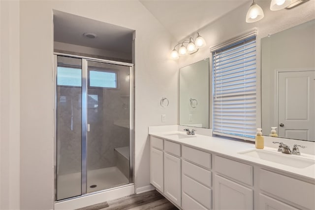 bathroom featuring an enclosed shower, dual bowl vanity, and hardwood / wood-style floors