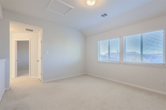 carpeted empty room with vaulted ceiling