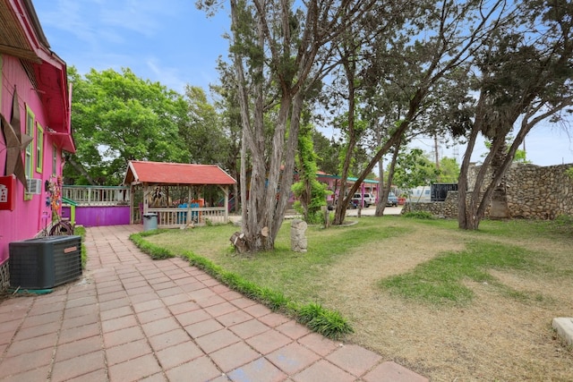 view of yard featuring central air condition unit and a patio