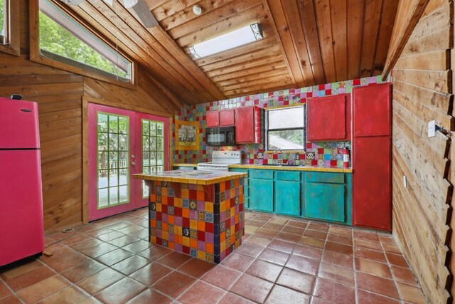 kitchen with wooden ceiling, white appliances, dark tile flooring, vaulted ceiling with skylight, and a healthy amount of sunlight