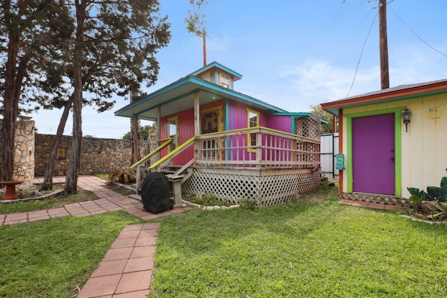 back of property with a yard, a porch, and a storage unit