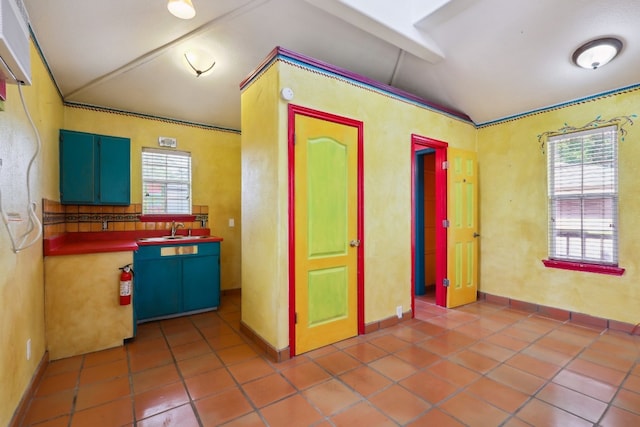 kitchen featuring sink, vaulted ceiling with beams, and tile floors