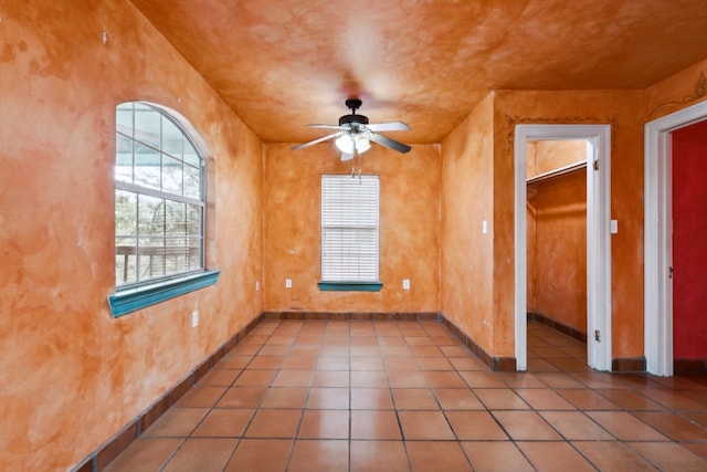 tiled spare room with ceiling fan