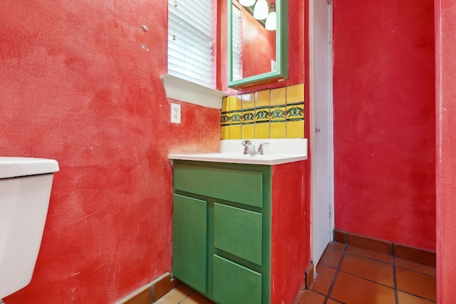 bathroom featuring toilet, vanity with extensive cabinet space, and tile flooring