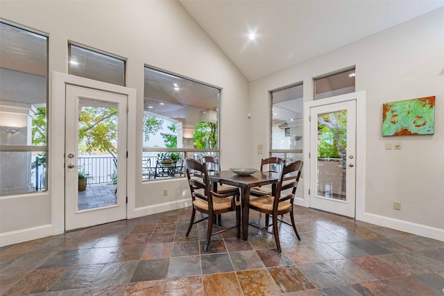 tiled dining room featuring high vaulted ceiling