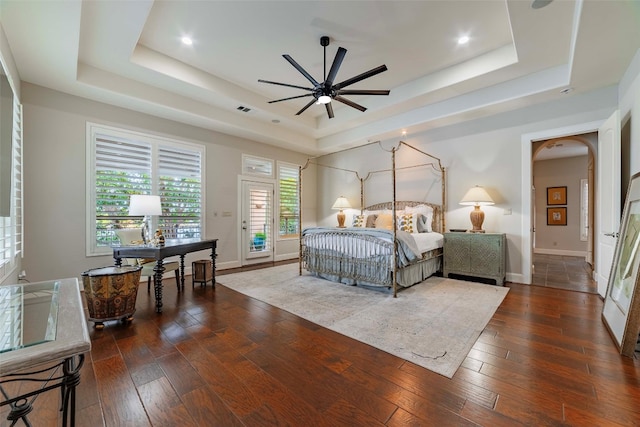 bedroom featuring wood-type flooring and a tray ceiling