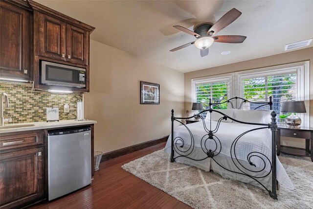 bedroom featuring ceiling fan, sink, and dark hardwood / wood-style flooring