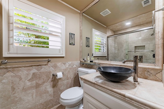 bathroom with tile walls, vanity, and toilet