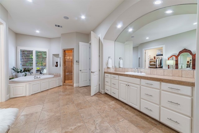 bathroom with tile patterned floors, vanity, and a washtub