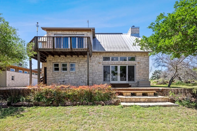 rear view of house featuring a lawn and a balcony