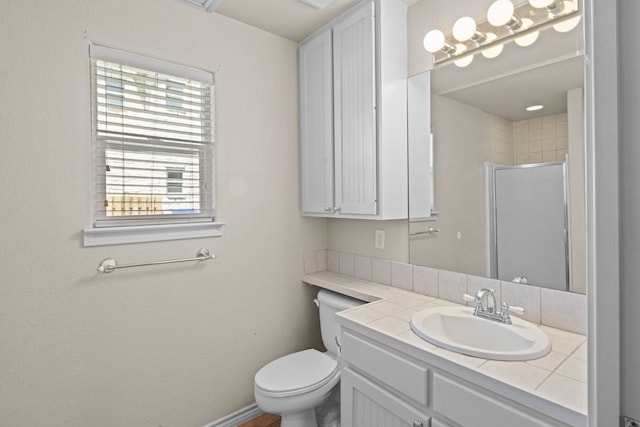 bathroom with toilet, vanity with extensive cabinet space, and a wealth of natural light