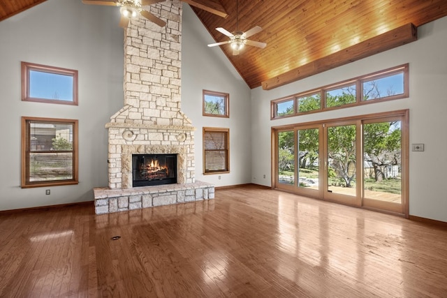 unfurnished living room featuring ceiling fan, beam ceiling, a fireplace, wood ceiling, and high vaulted ceiling