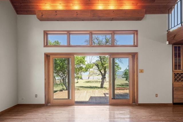 doorway featuring plenty of natural light, wood ceiling, a high ceiling, and wood-type flooring