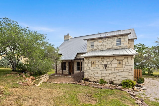 rear view of property featuring a lawn