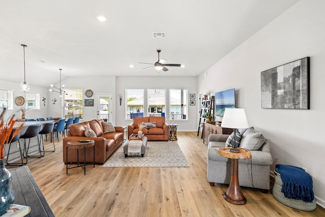 living room featuring light hardwood / wood-style floors and ceiling fan with notable chandelier