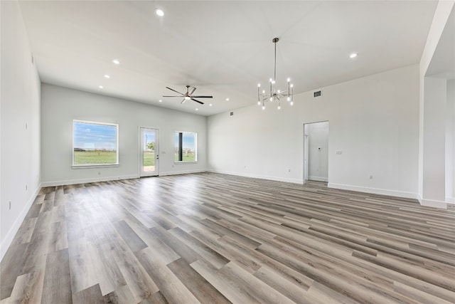 unfurnished living room with light wood-type flooring and ceiling fan with notable chandelier