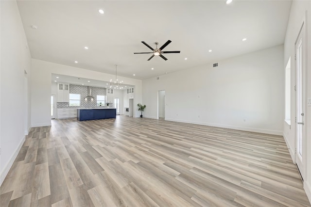 unfurnished living room featuring ceiling fan and light wood-type flooring