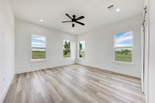 spare room featuring a wealth of natural light, light hardwood / wood-style flooring, and ceiling fan