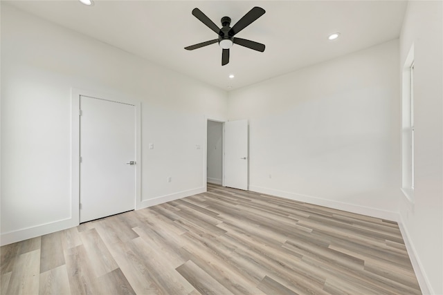 unfurnished bedroom with ceiling fan, light wood-type flooring, and a closet