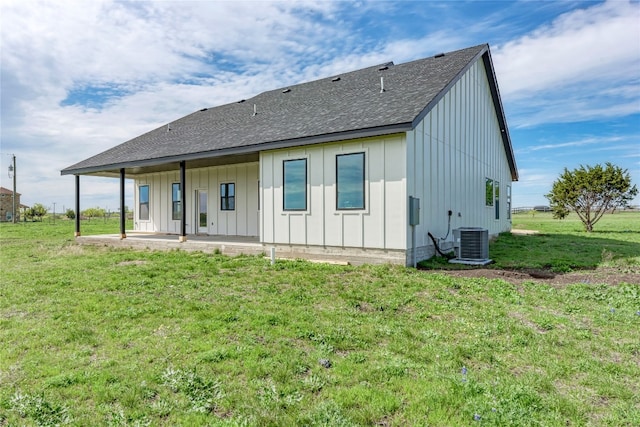 rear view of house with a lawn and central air condition unit