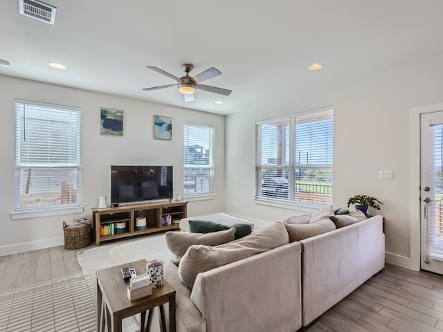 living room with ceiling fan and light hardwood / wood-style flooring