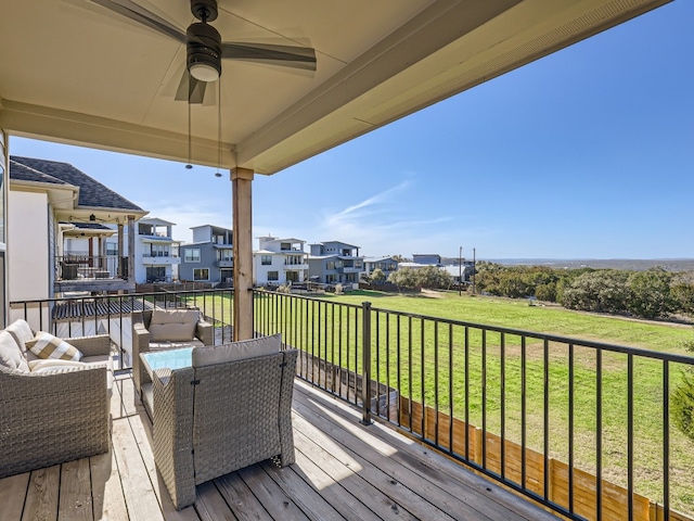 wooden deck featuring ceiling fan, outdoor lounge area, and a yard