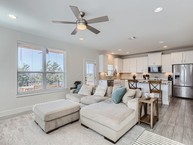 living room with ceiling fan and light wood-type flooring