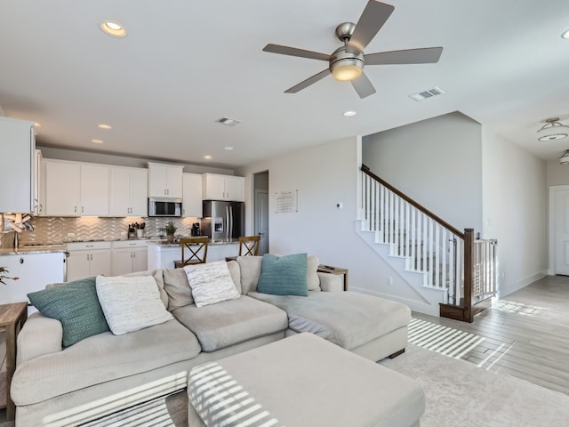 living room featuring light hardwood / wood-style floors and ceiling fan