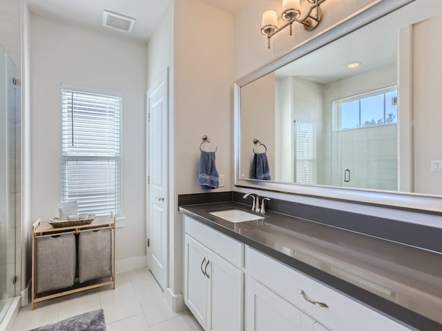 bathroom featuring vanity, tile floors, and a shower with door