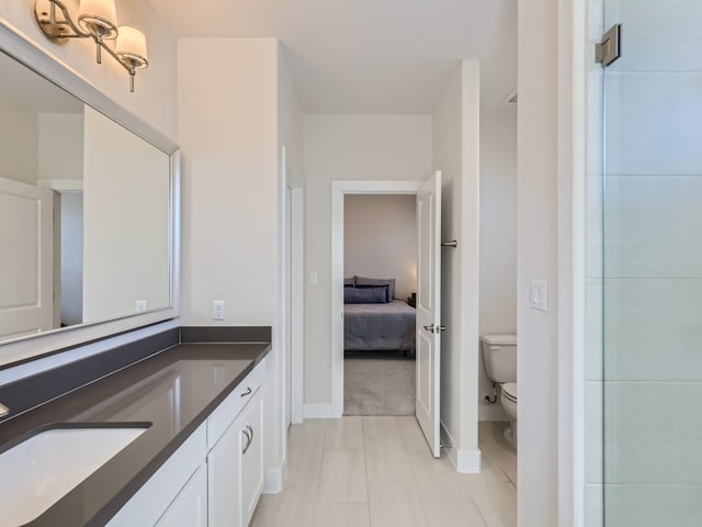 bathroom with toilet, tile flooring, and vanity