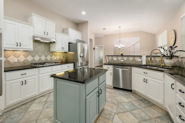 kitchen with appliances with stainless steel finishes, tasteful backsplash, an inviting chandelier, and a kitchen island