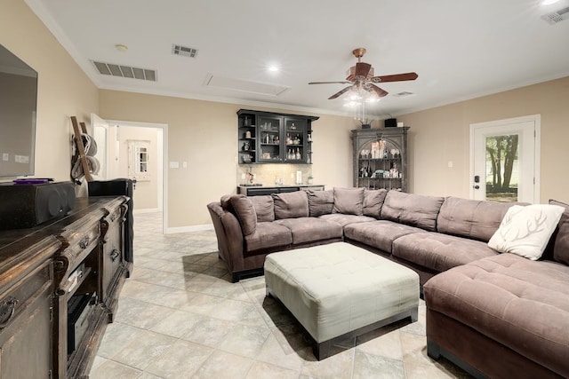 tiled living room with ceiling fan, crown molding, and indoor bar