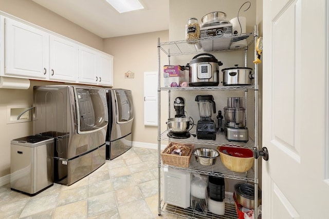 laundry room featuring light tile floors, cabinets, and washing machine and clothes dryer