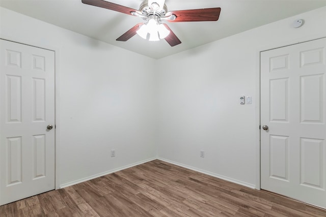 spare room with dark wood-type flooring and ceiling fan