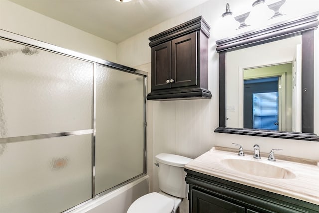 full bathroom featuring toilet, vanity, and bath / shower combo with glass door