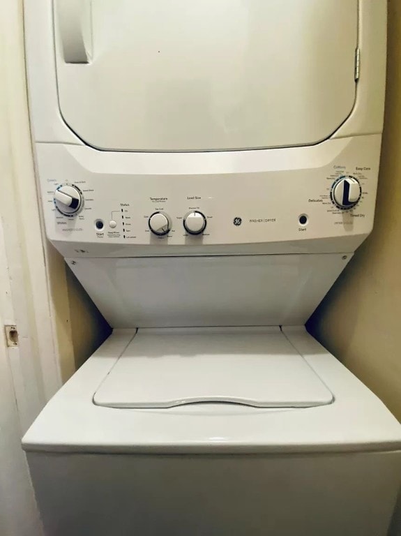 washroom featuring stacked washer and clothes dryer