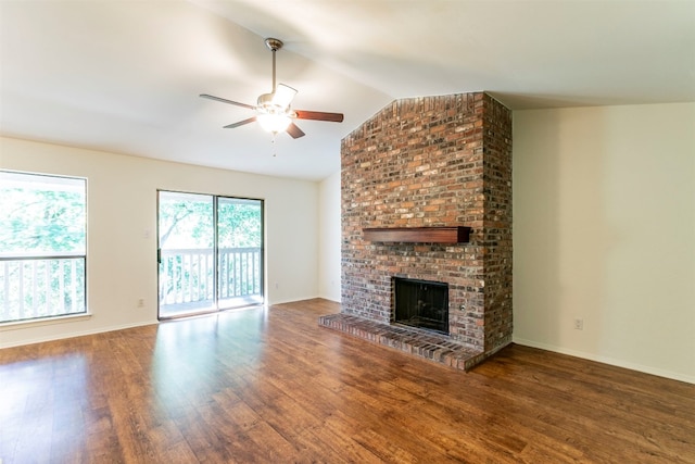 unfurnished living room featuring brick wall, ceiling fan, dark hardwood / wood-style flooring, a fireplace, and lofted ceiling